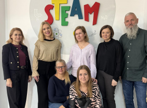 Grupa nauczycieli na tle loga STEAM